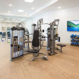 A modern gym equipped with a multi-station exercise machine and other fitness accessories.