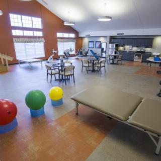 A spacious physical therapy room equipped with exercise balls and treatment tables.