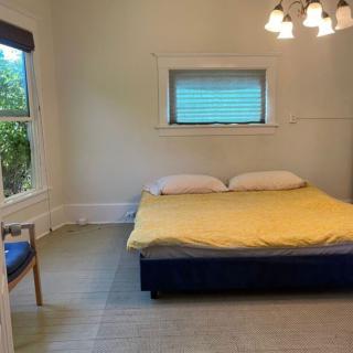 A minimalist bedroom with a large bed and ample natural light.