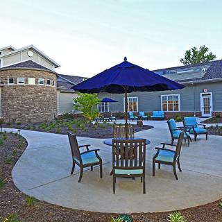 A patio area with seating and an umbrella outside a building.
