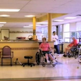 Elderly residents in wheelchairs at a nursing home facility.