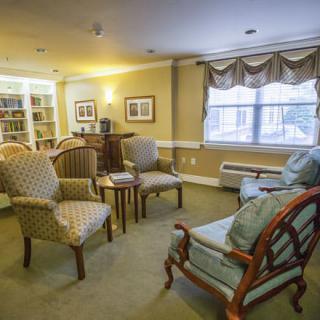 Cozy living room with comfortable chairs, a sofa, and a bookshelf.