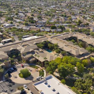 Aerial view of a suburban residential area with numerous buildings, roads, and greenery.