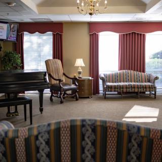 A cozy living room with elegant furniture and a piano.