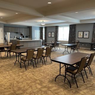 An empty conference room with arranged tables and chairs, ready for a meeting.