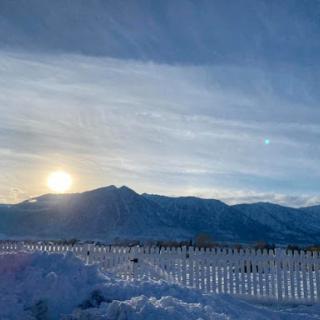 A serene winter sunset over snow-covered mountains.