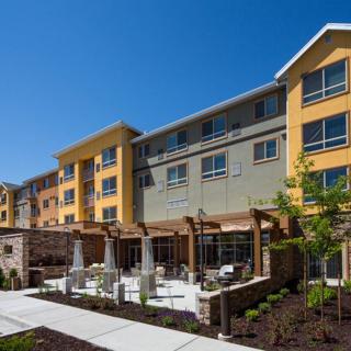 A modern hotel building with a landscaped outdoor patio area.