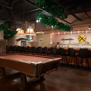 A cozy bar interior with a pool table and seating area.