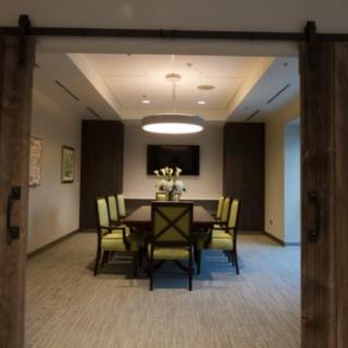 A modern conference room with a large table, stylish chairs, and a decorative lighting fixture.