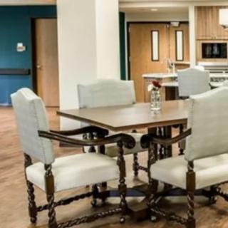 A cozy dining area with a wooden table and upholstered chairs.