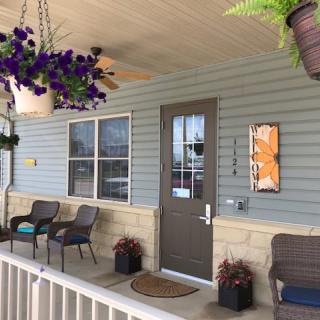 A cozy porch with patio furniture and hanging plants.