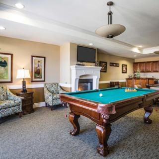 A cozy game room featuring a billiards table and comfortable seating.