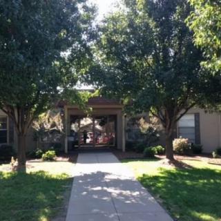 A path leading to a building entrance surrounded by trees.