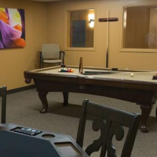 A cozy indoor game room featuring a pool table and wall art.