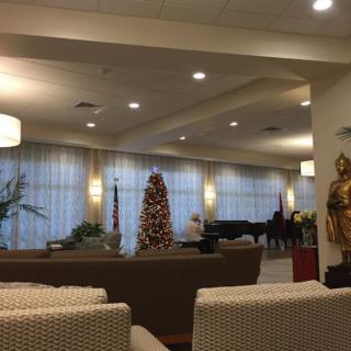 A cozy lobby featuring a decorated tree, seating area, and a piano.