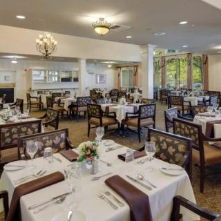 An elegant, formal dining room with neatly arranged tables and chairs.