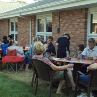 A group of people enjoying a casual gathering in a backyard.