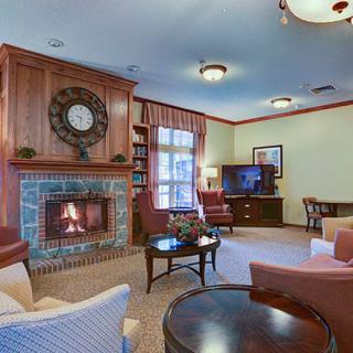 A cozy living room featuring a fireplace, comfortable seating, and a television.