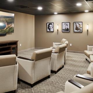 A modern home theater with comfortable seating and wall-mounted artwork.