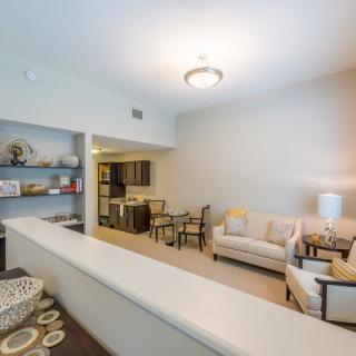 A modern apartment living room with a cozy sofa and dining area.