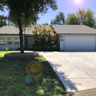 A charming single-family home featuring a well-kept front yard and a garage.