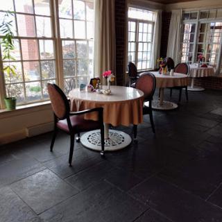 A cozy dining area featuring elegantly set tables, surrounded by natural light.