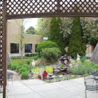 A serene garden view with a fountain and well-maintained plants.