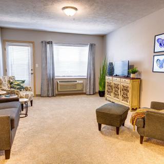 A cozy living room with comfortable seating, a television, and natural light from the window.