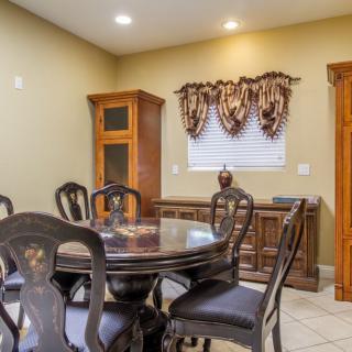 A cozy dining room with a round table, chairs, and wooden cabinetry.