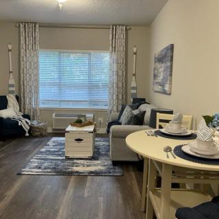 Cozy living room with modern decor, featuring a sofa, coffee table, and dining area.