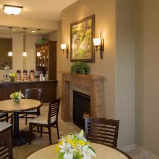 A cozy dining area featuring a fireplace, tables with flower arrangements, and decorative lighting.