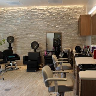 A modern hair salon featuring stylish barber chairs and a sleek interior design.