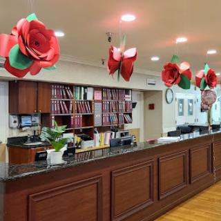 An inviting hotel reception area decorated with vibrant paper flowers.