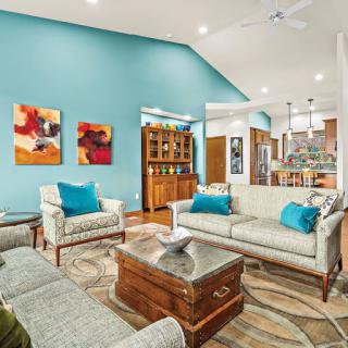 A beautifully designed living room featuring vibrant blue walls and stylish furniture.