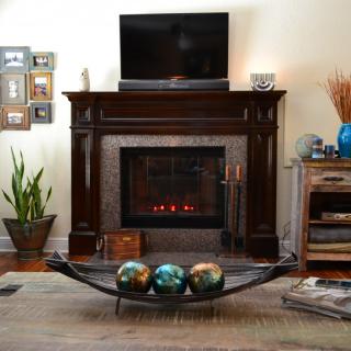 A cozy living room with a fireplace, television, and decorative elements.