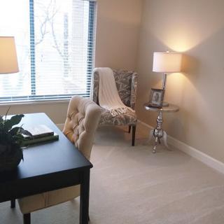 A cozy home office with a desk, chair, and lamps providing an inviting workspace.