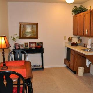 Cozy kitchen and dining area with wooden cabinets and a small dining table.