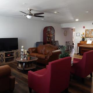 A cozy living room featuring comfortable seating arrangements and a piano.