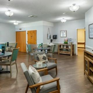 A modern, well-lit interior room with comfortable seating and wooden flooring.