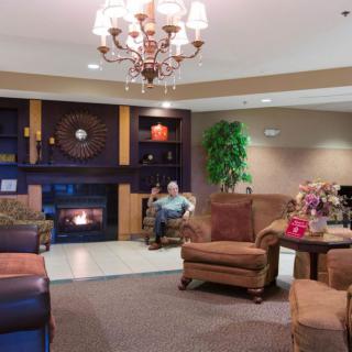 A cozy hotel lobby with comfortable seating and a warm fireplace.