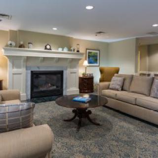 A cozy living room with a fireplace, comfortable sofas, and elegant furnishings.