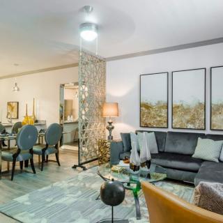A modern living and dining space featuring stylish furniture and contemporary artwork.