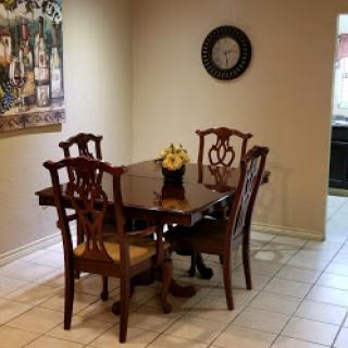 A cozy dining area featuring a wooden table and chairs, complemented by tasteful wall art.