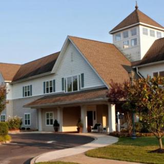 A large, residential building with a distinctive roof and landscaped surroundings.