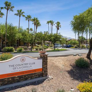 Entrance to the Country Club of a Desert Community with Palm Trees and a Desert Landscape.