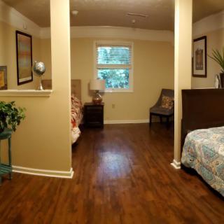 A cozy bedroom with twin beds and a wooden floor.