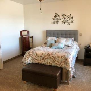 A cozy bedroom with a decorative bed and wall art.