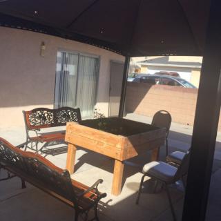 A patio area with a gazebo, bench, chairs, and a table.