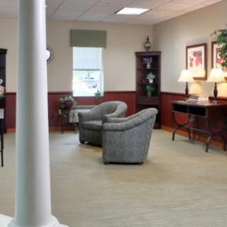 A cozy living room with comfortable seating, bookshelves, and ambient lighting.