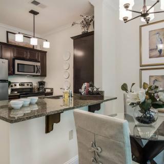 Modern kitchen and dining area with stainless steel appliances and elegant decor.